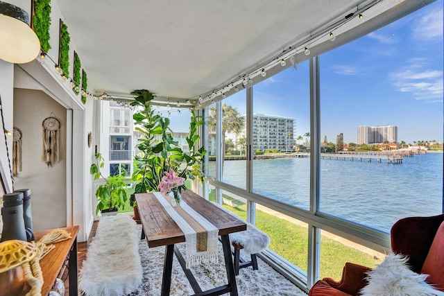 sunroom featuring a water view