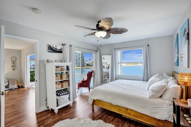 bedroom with ceiling fan, multiple windows, dark hardwood / wood-style flooring, and access to outside