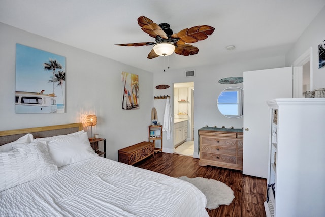 bedroom with dark wood-type flooring, ceiling fan, and connected bathroom