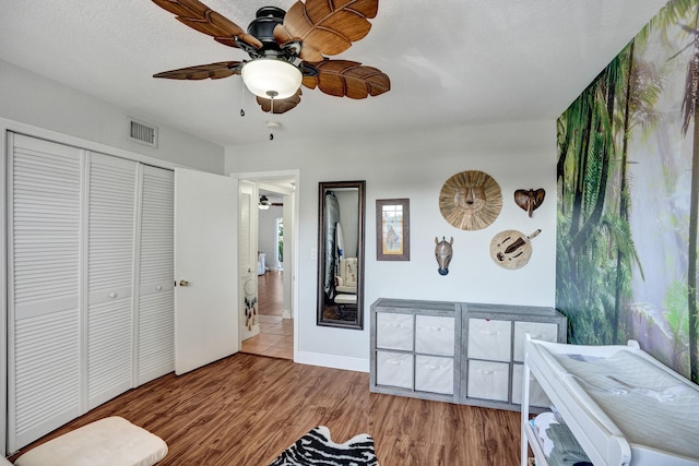 interior space with light wood-type flooring, ceiling fan, and a textured ceiling