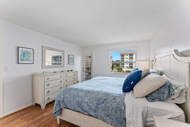 bedroom featuring light wood-type flooring and a textured ceiling