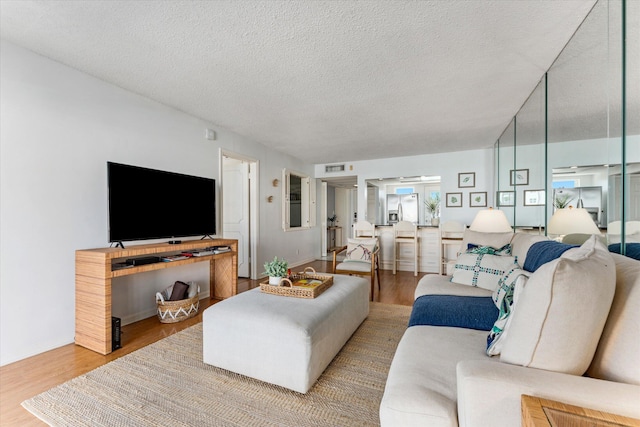 living room featuring wood-type flooring and a textured ceiling