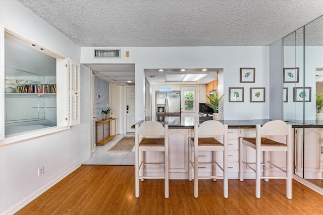 dining area with a textured ceiling and light wood-type flooring