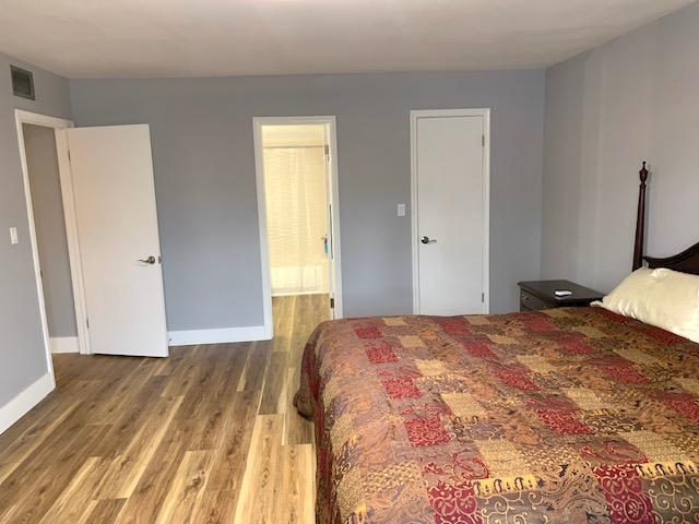 bedroom with hardwood / wood-style floors and ensuite bathroom