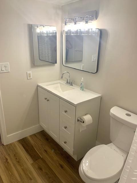 bathroom featuring toilet, vanity, and hardwood / wood-style flooring