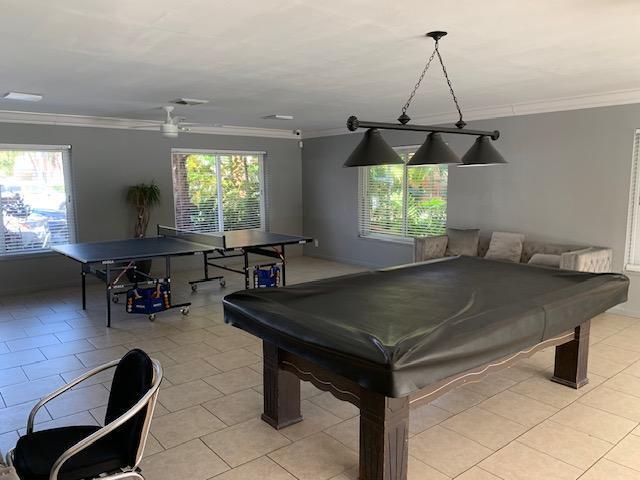 game room featuring ornamental molding, pool table, light tile patterned flooring, and plenty of natural light