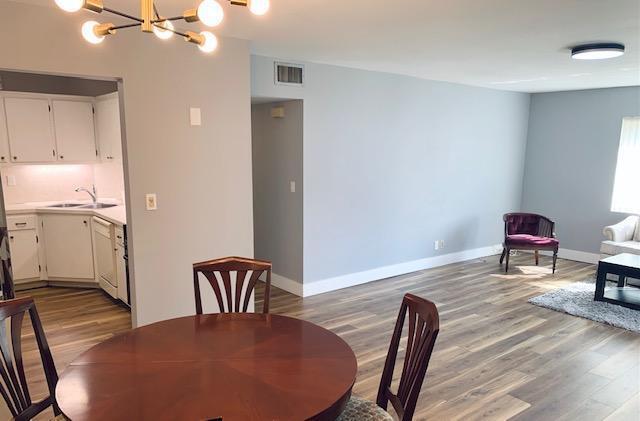 dining area featuring hardwood / wood-style floors, a chandelier, and sink