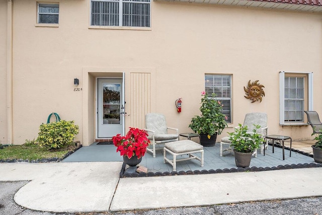 view of exterior entry with a patio area