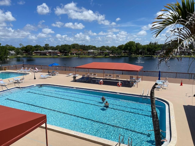 view of pool featuring a patio and a water view