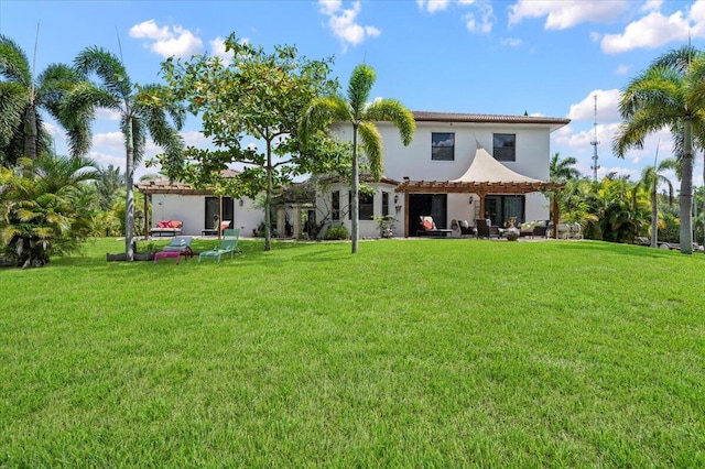 back of house featuring a lawn and a pergola