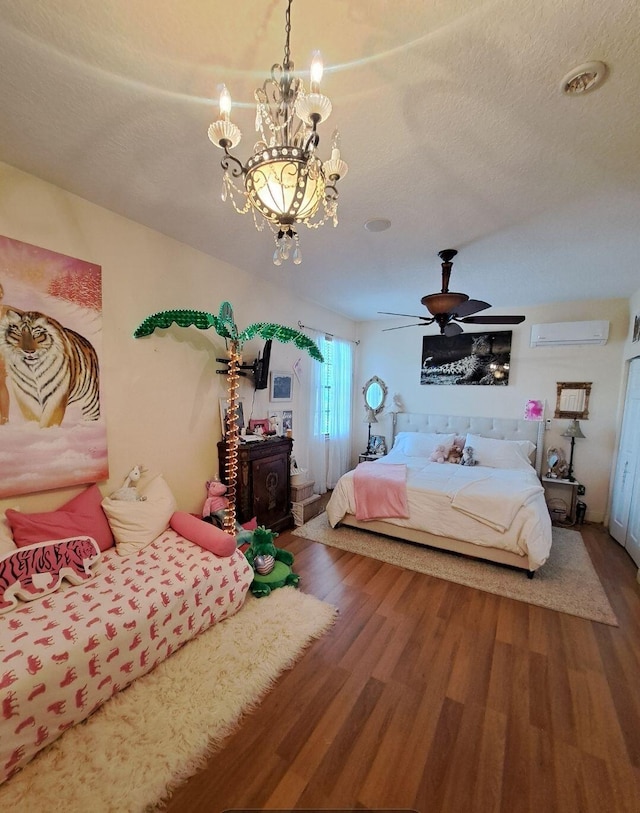 bedroom with an AC wall unit, a notable chandelier, a textured ceiling, and hardwood / wood-style floors