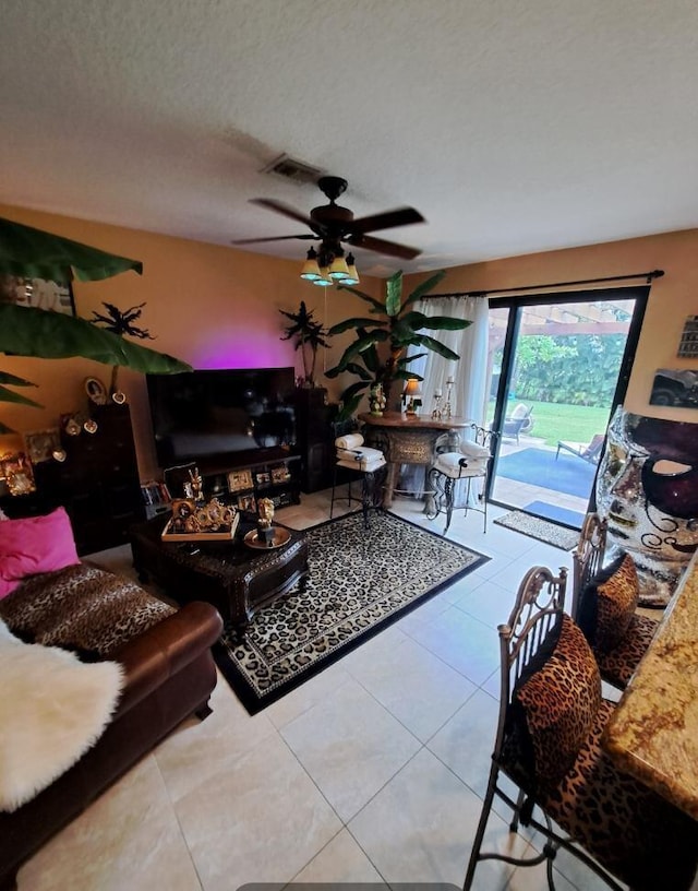 tiled living room featuring a textured ceiling and ceiling fan