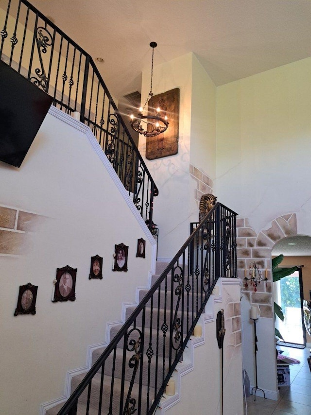 stairs featuring a chandelier