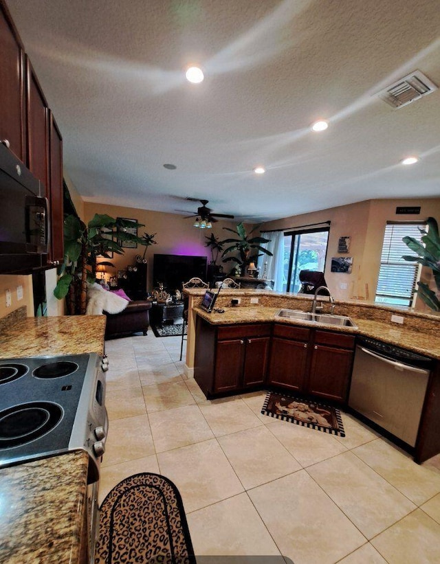 kitchen featuring kitchen peninsula, sink, stainless steel appliances, light tile patterned floors, and light stone counters