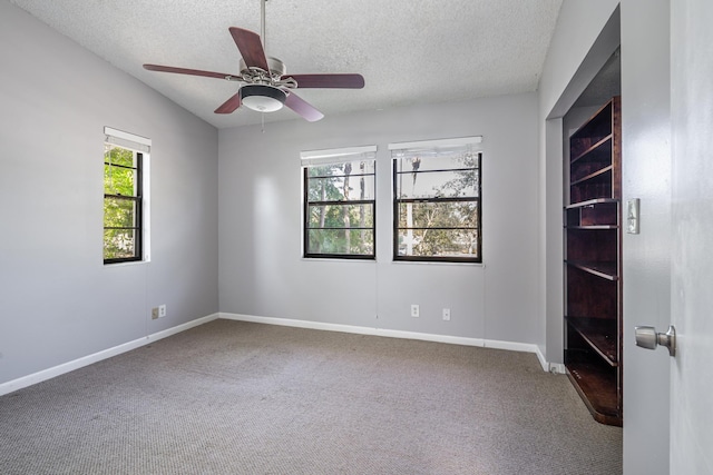 carpeted empty room featuring vaulted ceiling, a textured ceiling, and ceiling fan