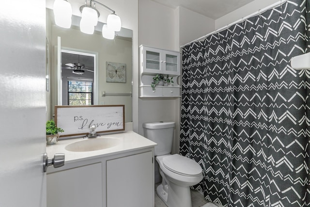 bathroom with ceiling fan, walk in shower, vanity, and toilet