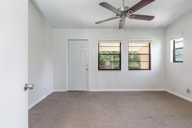 carpeted spare room featuring a textured ceiling and ceiling fan