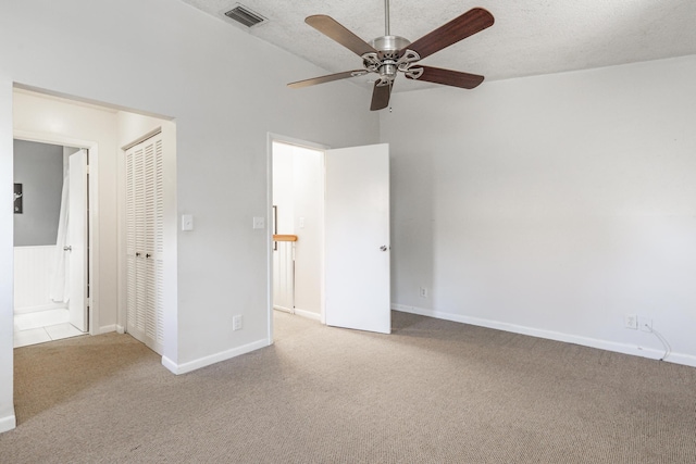 carpeted empty room featuring a textured ceiling and ceiling fan