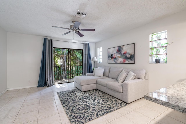 tiled living room with a textured ceiling and ceiling fan