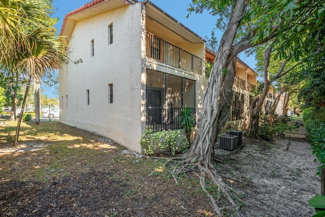 view of side of property featuring a balcony and central AC unit