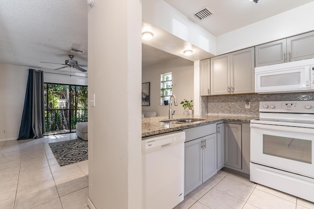 kitchen with white appliances, dark stone countertops, gray cabinetry, and sink