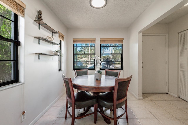 dining room with a textured ceiling and light tile patterned floors