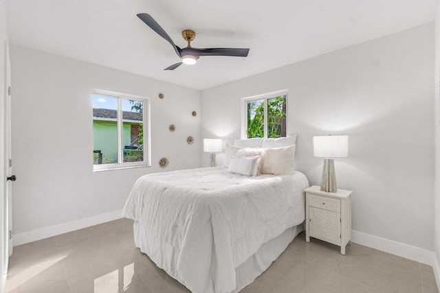 tiled bedroom featuring ceiling fan and multiple windows