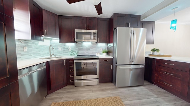 kitchen featuring decorative light fixtures, tasteful backsplash, appliances with stainless steel finishes, ceiling fan, and sink