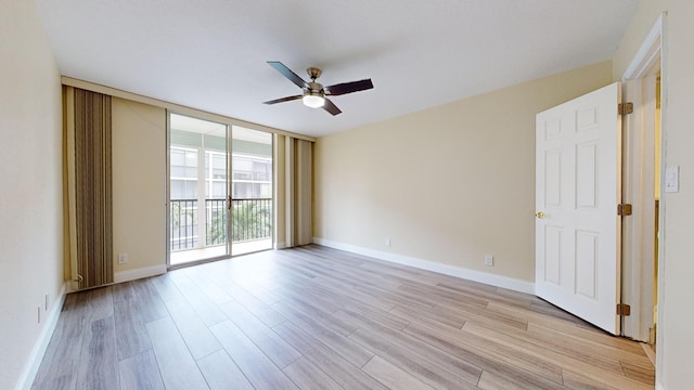 empty room with ceiling fan, floor to ceiling windows, and light hardwood / wood-style flooring