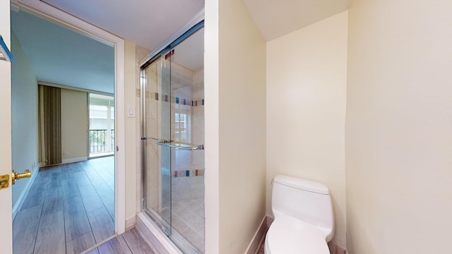 bathroom featuring toilet, walk in shower, and hardwood / wood-style flooring