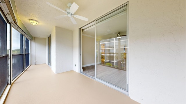 unfurnished sunroom with ceiling fan