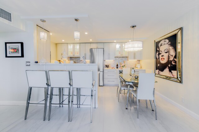 kitchen featuring a chandelier, stainless steel appliances, light tile patterned floors, sink, and white cabinetry