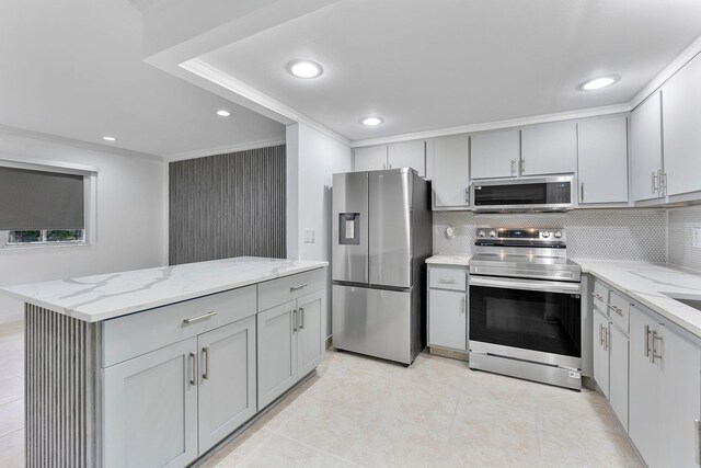 527 Brittany Unit K, Delray Beach, FL 33446 - kitchen featuring light stone counters, decorative backsplash, appliances with stainless steel finishes, and gray cabinets