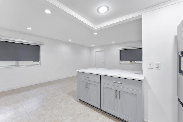 kitchen featuring light stone counters, light tile patterned floors, crown molding, and gray cabinets