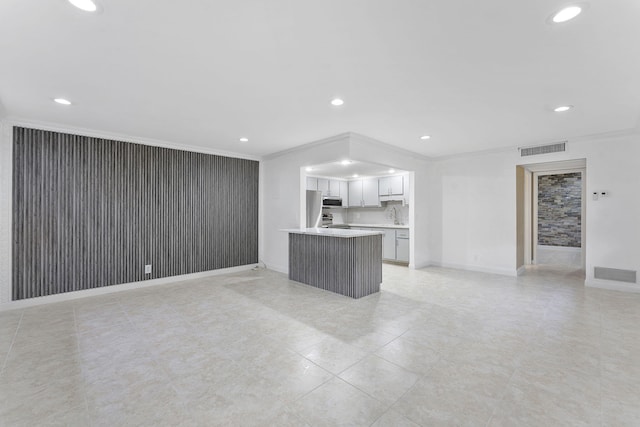 unfurnished living room featuring sink and ornamental molding