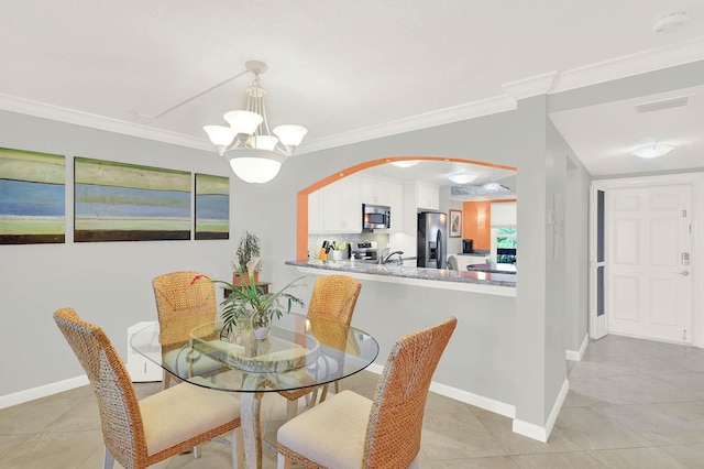 tiled dining space featuring ornamental molding and a notable chandelier