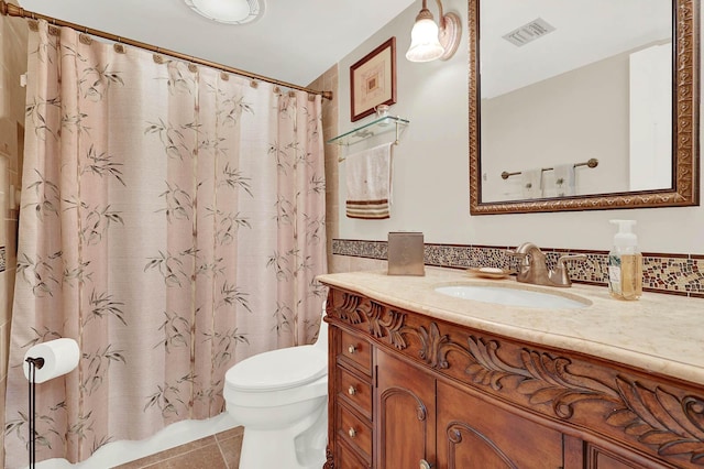 bathroom featuring toilet, tile patterned flooring, and vanity