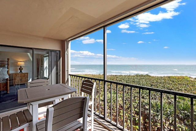 balcony with a water view and a beach view