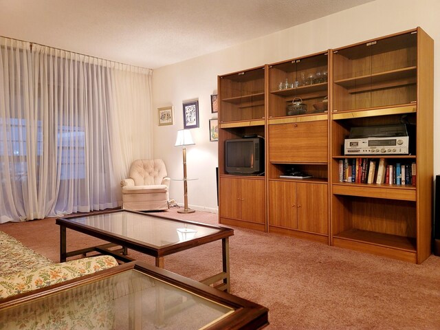 living room with a textured ceiling, a notable chandelier, and carpet floors