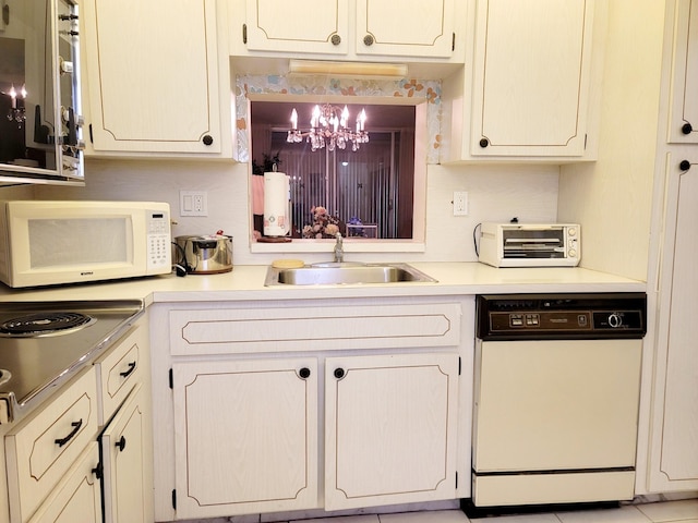 kitchen featuring sink, a chandelier, and white appliances