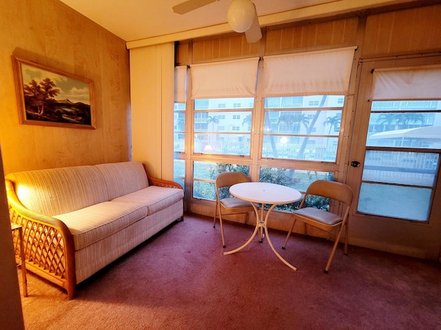 interior space with ceiling fan and wooden walls