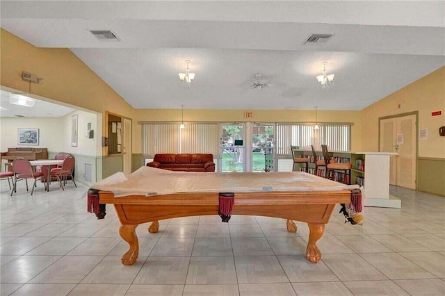 recreation room with ceiling fan with notable chandelier, vaulted ceiling, light tile patterned floors, and billiards