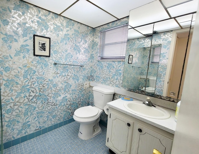 bathroom with toilet, vanity, and tile patterned floors