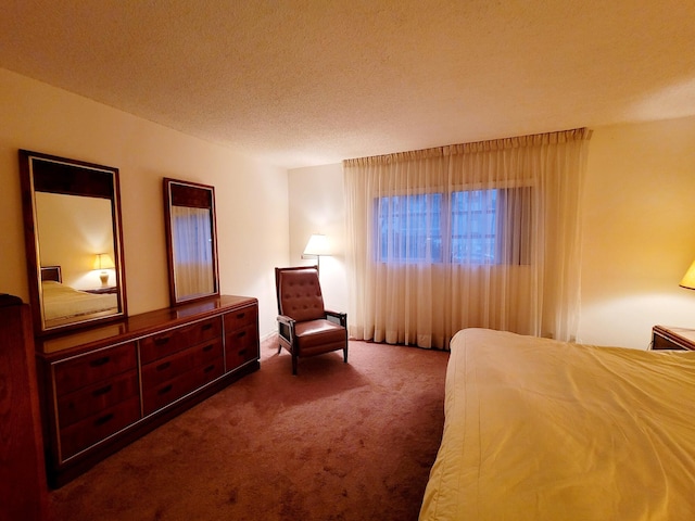 bedroom featuring a textured ceiling and dark colored carpet