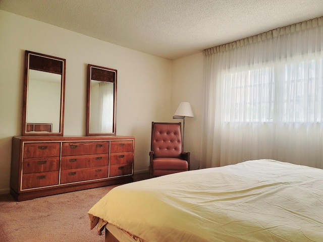 bedroom with light colored carpet and a textured ceiling