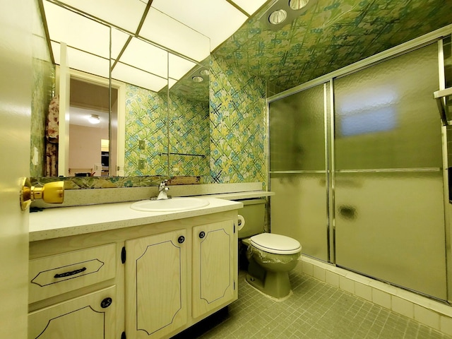 bathroom with vanity, toilet, an enclosed shower, and tile patterned flooring