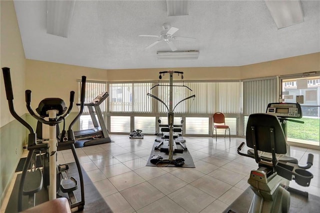 workout room featuring a textured ceiling, ceiling fan, and a wealth of natural light