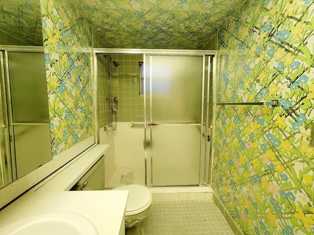 bathroom with tile patterned flooring, vanity, a shower with door, and toilet