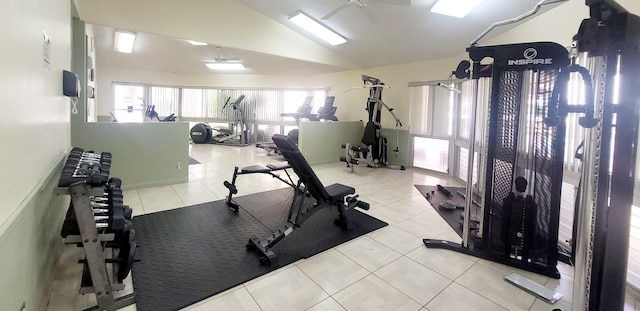 exercise area featuring light tile patterned flooring, vaulted ceiling, and ceiling fan