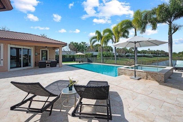 view of pool with a patio area, ceiling fan, and an in ground hot tub